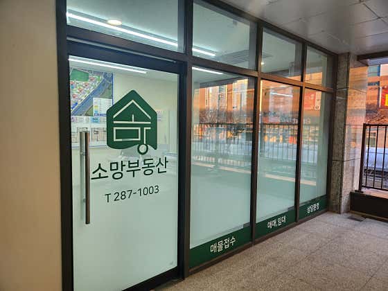 소망부동산 상호가 표시된 실제 유리 출입문